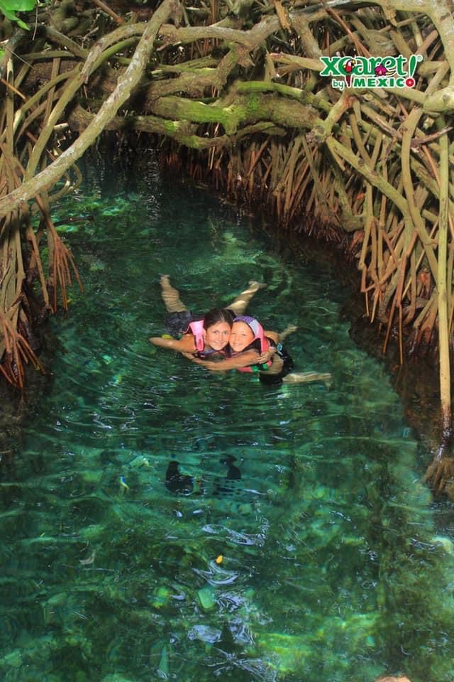 Traveling Trio Family exploring canals in Xcaret park, Mexico